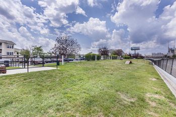 A grassy field with a fence and a building in the background.